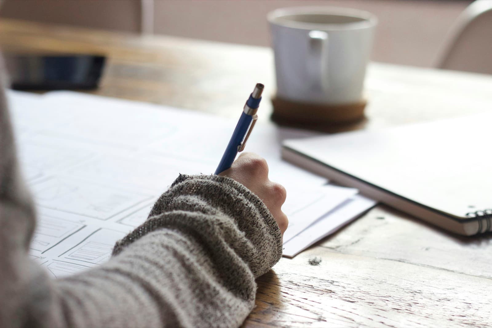 A quiet moment writing at a desk with a warm cup of coffee — getting started with therapy