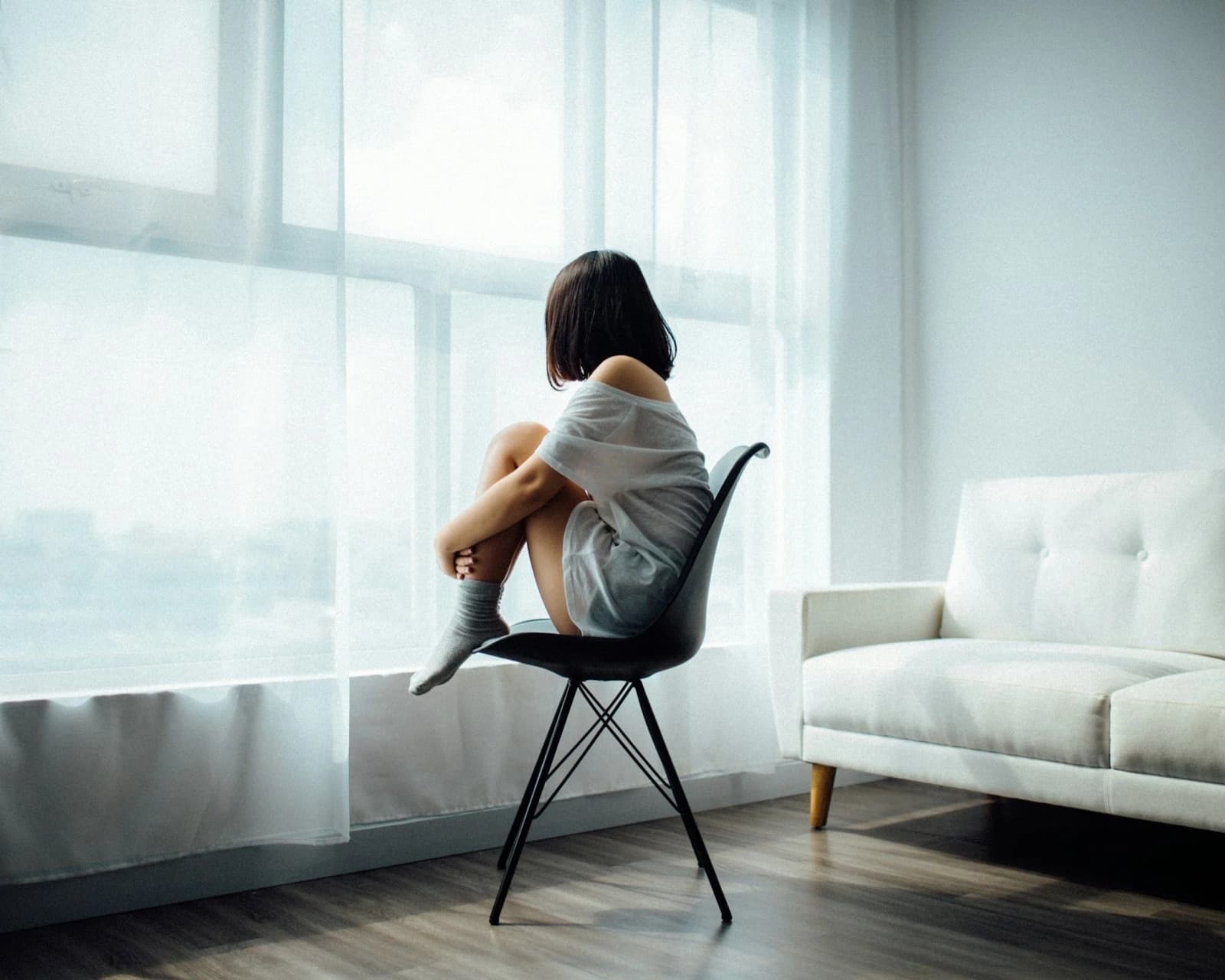 A person sitting quietly by a window — postpartum depression therapy in Nashville, TN
